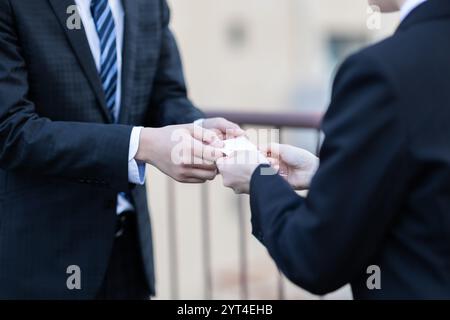 Uomo e donna che scambiano biglietti da visita in mano Foto Stock