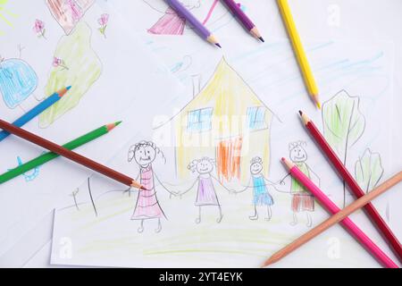 Disegno per bambini di una famiglia felice e matite sul tavolo, vista dall'alto Foto Stock