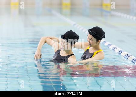 Donna che insegna a nuotare in piscina Foto Stock