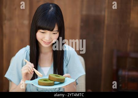 Giovane donna che si diverte il tè Foto Stock