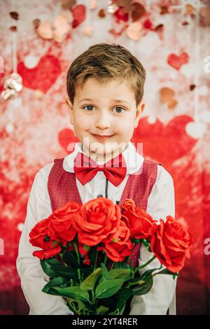 Ragazzo in gilet rosso con bouquet di rose, sfondo a cuore Foto Stock