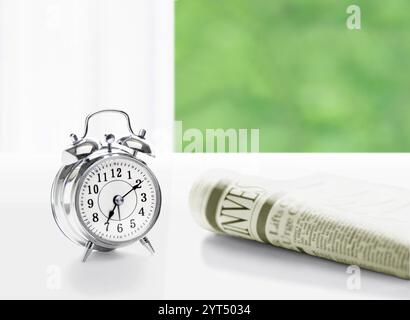 Sveglia e quotidiano sul davanzale Foto Stock
