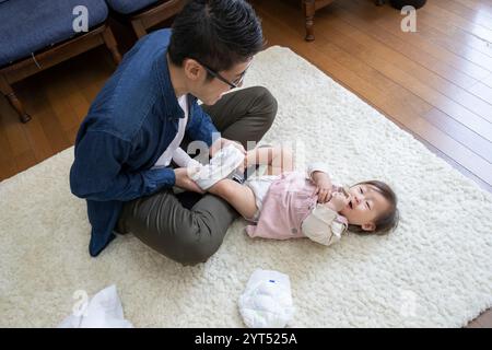 Padre cambiando pannolino per bambini Foto Stock