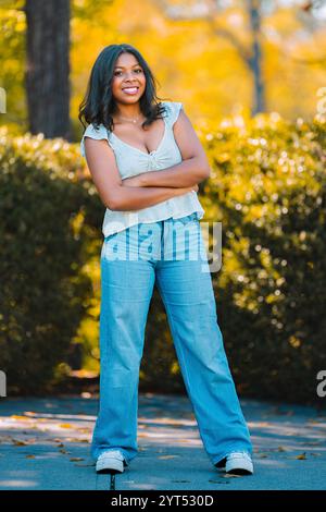 Teenager che posa nel parco con un grande sorriso Foto Stock