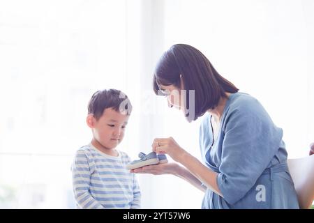 Donna che mantiene il bambino scarpe Foto Stock