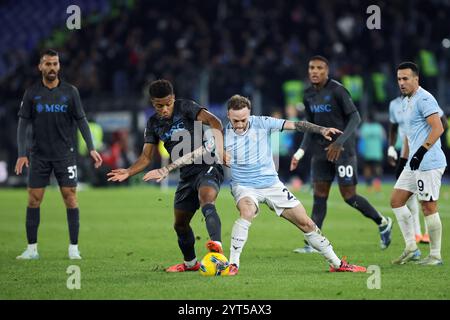 Roma, Italia. 5 dicembre, 2024. Cyril Ngonge del Napoli si batte per il pallone con Manuel Lazzari della Lazio durante la Coppa Italia, round di 16 fa Foto Stock