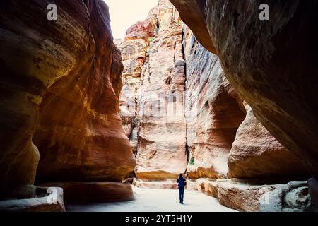 Turisti in stretto passaggio di rocce del canyon di Petra in Giordania. Petra è un sito patrimonio dell'umanità dell'UNESCO dal 1985. Attraverso la gola di Siq fino alla pietra Foto Stock