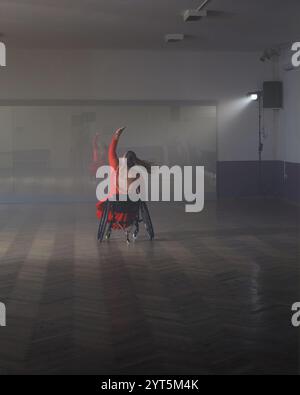 Donna para che balla, gira e gira nella sala da ballo durante la lezione di formazione. Danza e disabilità. Foto Stock