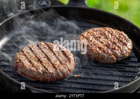 polpette di carne fresca di hamburger sulla griglia Foto Stock