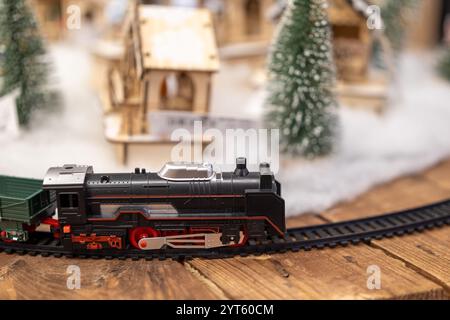 Treno giocattolo che viaggia in treno con sfondo invernale e albero di Natale Foto Stock