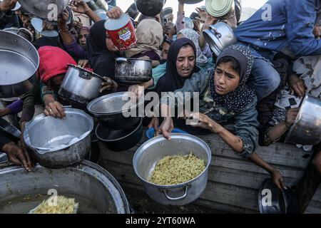 Khan Younis, territori palestinesi. 6 dicembre 2024. I palestinesi sfollati si affollano per ricevere i pasti dalla Rafah Charitable Kitchen (Tekia) a Khan Younis. Le Nazioni Unite e le organizzazioni internazionali mettono in guardia dalla carestia nella Striscia di Gaza ed esortano tutte le parti in conflitto, le fazioni palestinesi e il governo israeliano a consentire l'ingresso di camion umanitari nella Striscia di Gaza e a facilitare le loro missioni al fine di evitare un disastro umanitario a Gaza a causa del conflitto in corso tra Israele e Hamas. Crediti: Abed Rahim Khatib/dpa/Alamy Live News Foto Stock