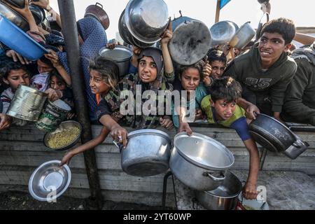 Khan Younis, territori palestinesi. 6 dicembre 2024. I palestinesi sfollati si affollano per ricevere i pasti dalla Rafah Charitable Kitchen (Tekia) a Khan Younis. Le Nazioni Unite e le organizzazioni internazionali mettono in guardia dalla carestia nella Striscia di Gaza ed esortano tutte le parti in conflitto, le fazioni palestinesi e il governo israeliano a consentire l'ingresso di camion umanitari nella Striscia di Gaza e a facilitare le loro missioni al fine di evitare un disastro umanitario a Gaza a causa del conflitto in corso tra Israele e Hamas. Crediti: Abed Rahim Khatib/dpa/Alamy Live News Foto Stock