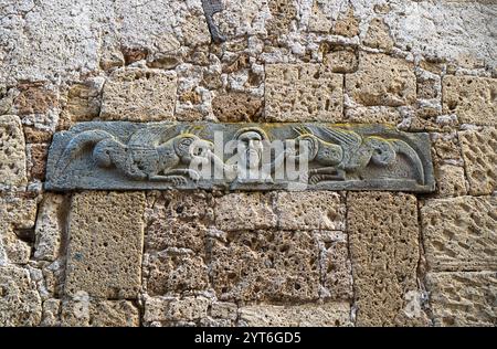 Rilievo del XII secolo intagliato sulla parete esterna della Chiesa di Santa Maria (nota anche come Chiesa di San Rocco) a Pitigliano, Grosseto, Toscana Foto Stock