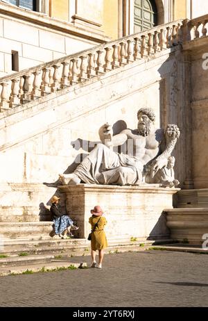 Turisti accanto alla statua del Nilo, parte della fontana del Palazzo Senatorio, Roma, Italia Foto Stock