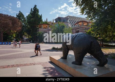 Statua dell'orso di Bruin presso il campus dell'UCLA con studenti ed edifici universitari Foto Stock