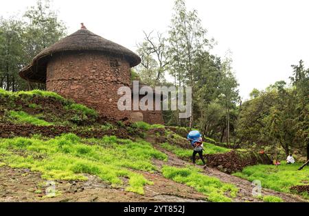 Gli abitanti del villaggio tornano alla loro tradizionale casa rotonda a due piani con scale interne e tetti di paglia, Lalibela, Etiopia Foto Stock
