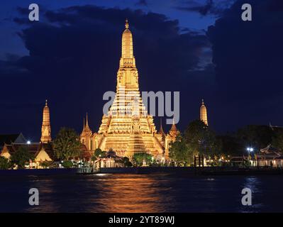 Tempio Wat Arun illuminato di notte con bei riflessi sul fiume a Bangkok, Thailandia Foto Stock