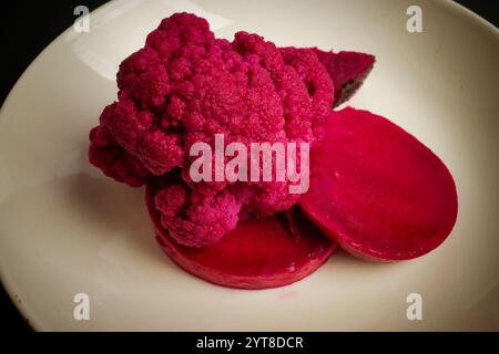 Piatto con vivaci fette di cavolfiore viola e barbabietola Foto Stock