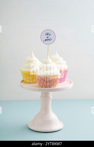 Tre cupcake per la nascita di una bambina con crema di burro su un portagomma Foto Stock