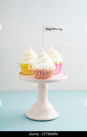 Tre cupcake per la festa della mamma con crema di burro su un supporto per torte Foto Stock