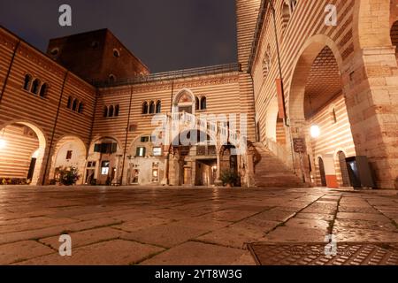 Il cortile del Palazzo della ragione di Verona di sera, illuminato da lampioni Foto Stock