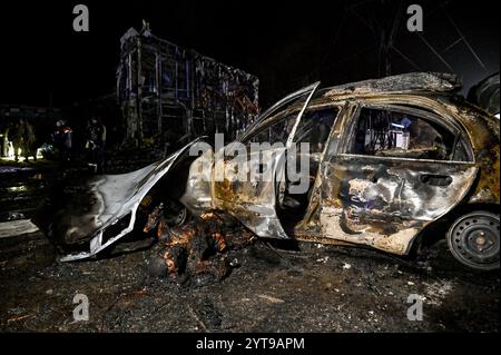 ZAPORIZHZHIA, UCRAINA - 6 DICEMBRE 2024 - Un corpo bruciato è a terra da un'auto calcinata dopo un attacco aereo russo, Zaporizhzhia, Ucraina sudorientale. Venerdì sera, l'esercito russo ha effettuato due attacchi contro Zaporizhzhia e il distretto di Zaporizhzhia. Il primo sciopero che ha colpito un'area residenziale nel centro regionale ha distrutto un negozio di riparazione auto e danneggiato case e negozi nelle vicinanze. Almeno dieci persone sono rimaste uccise e 22 sono rimaste ferite. Il secondo sciopero ha colpito un'area aperta nel distretto di Zaporizhzhia. Secondo la polizia regionale di Zaporizhzhia, le truppe russe attaccarono la città Foto Stock