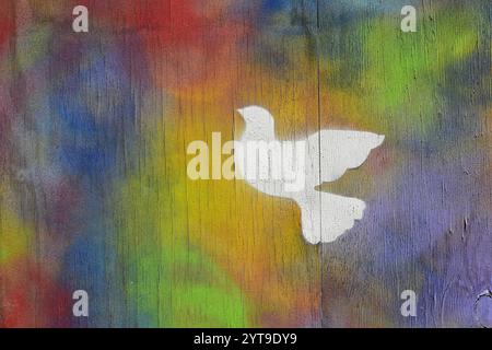Graffito colorato con una colomba di pace su una parete di legno Foto Stock