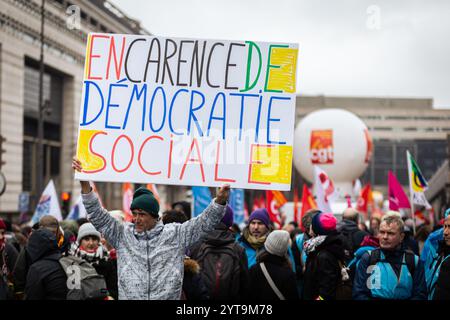 Parigi, Francia. 5 dicembre 2024. Un manifestante ha in mano un cartello che dice "in assenza di democrazia sociale” durante la manifestazione della funzione pubblica francese. Circa 200.000 persone hanno manifestato in tutta la Francia, secondo la CGT (Confederazione generale del lavoro) in un giorno di scioperi del servizio civile, nonostante la caduta del governo francese a causa del voto su una mozione di censura in seno all'Assemblea nazionale. A Parigi, circa 3.000 persone hanno preso parte alla manifestazione per chiedere maggiori risorse per il servizio pubblico e per avvertire del '' deterioramento˜' delle loro ''˜condizioni di lavoro e payâ (C Foto Stock