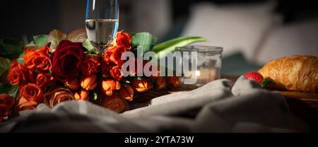 Colazione con rose rosse e champagne a letto. Sfondo romantico per san valentino o per la festa della mamma. Foto Stock