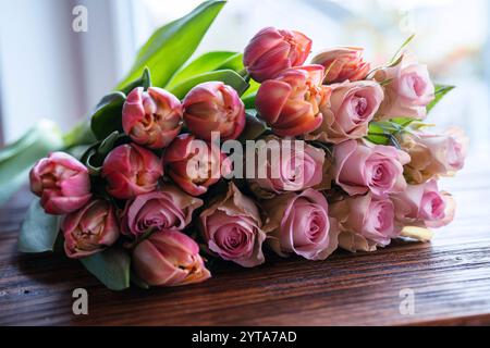 Bouquet di bellissime rose rosa e tulipani su legno scuro. Concept background per il giorno della mamma, san valentino e matrimoni. Foto Stock