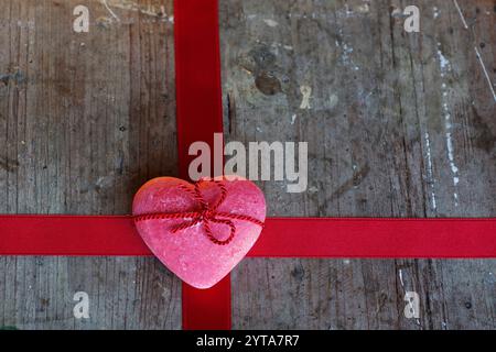 Romantico sfondo rustico con un nastro rosso e di cuore per il giorno di San Valentino Foto Stock