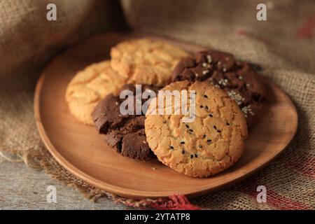 Biscotti al sesamo di cereali su piatto di legno Foto Stock