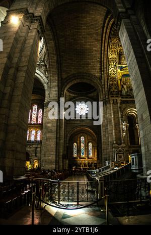 Interno ad arco della Basilica del Sacro cuore con luce che si riflette su lavori in pietra - Parigi, Francia Foto Stock