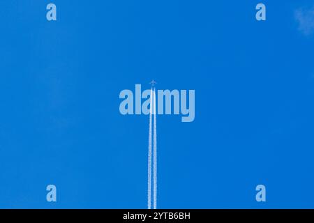 L'aereo lascia una pista bianca in alto nel cielo. Foto Stock