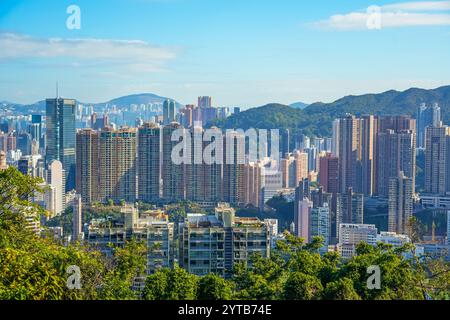 Il denso sviluppo urbano di edifici alti e sottili si affaccia su Hong Kong delle aree cittadine con parchi e aree di parco Foto Stock