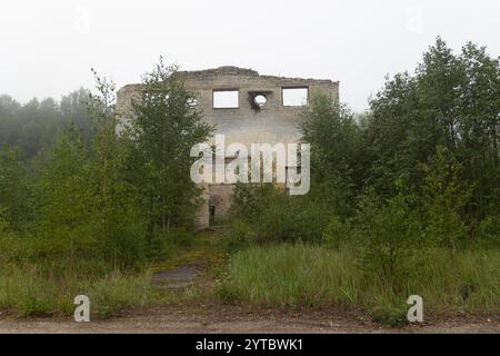 Le rovine della costruzione nella vecchia base dell'esercito sovietico in Lettonia, Europa. Casa crollata. Foto Stock