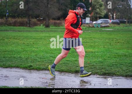 Londra, Regno Unito. 7 dicembre 2024 Un jogger che corre a Wimbledon comune come Storm Darragh colpisce il Regno Unito con forti raffiche di pioggia e vento che superano i 60 km/h il Met Office emette avvisi meteo rossi e gialli come Storm Darragh con condizioni di guida difficili, chiusure del Royal Park, ritardi di viaggio e inondazioni. Credito. Amer Ghazzal/Alamy Live News Foto Stock