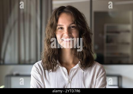 Ritratti alla testa di una giovane donna, indossa una camicia casual che guarda la fotocamera Foto Stock
