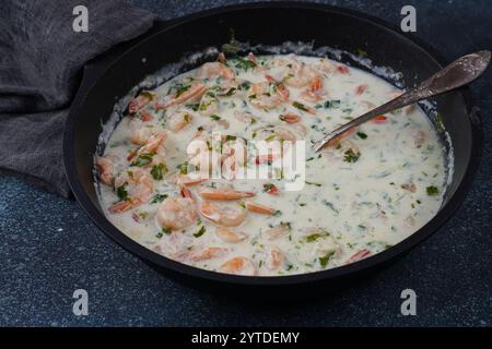 Gamberi con spinaci e parmigiano in salsa panna da vicino Foto Stock