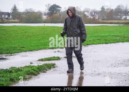 Londra, Regno Unito. 7 dicembre 2024 Un camminatore a Wimbledon comune come Storm Darragh colpisce il Regno Unito con forti piogge e raffiche di vento superiori a 60 km/h il Met Office emette avvisi meteo rossi e gialli come Storm Darragh con condizioni di guida difficili, chiusure del Royal Park, ritardi di viaggio e inondazioni. Credito. Amer Ghazzal/Alamy Live News Foto Stock