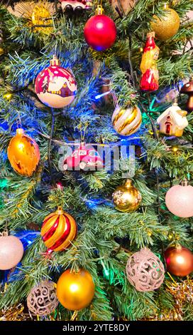 Albero di Natale decorato con una varietà di bellissimi giocattoli, sfondo luminoso e colorato per le vacanze Foto Stock