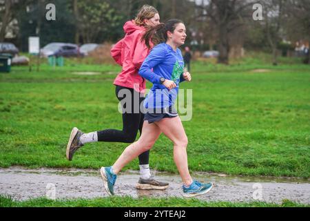 Londra, Regno Unito. 7 dicembre 2024 due jogger femminili su Wimbledon che corrono in condizioni di blustery mentre la tempesta Darragh colpisce il Regno Unito con forti raffiche di pioggia e vento oltre i 60 km/h il Met Office emette avvisi meteo rossi e gialli come Storm Darragh con condizioni di guida difficili, chiusure del Royal Park, ritardi di viaggio e inondazioni. Credito. Amer Ghazzal/Alamy Live News Foto Stock