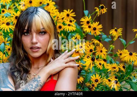 Una radiosa giovane donna messicana americana con capelli bicolore, che mescola marrone scuro e caramello, sorride calorosamente. Le piace una giornata estiva di sole al parco, Foto Stock