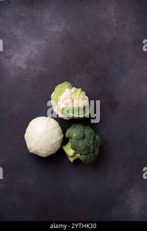 Disposizione di verdure, assortimento di cavoli freschi e biologici (broccoli, cavolo bianco, cavolfiore) su sfondo grigio, vista ad angolo alto Foto Stock