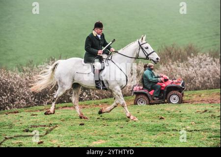 maschio bianco, a cavallo di un cavallo grigio, con un quad e ciclisti sullo sfondo Foto Stock