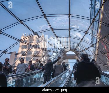 New York, New York, Stati Uniti d'America – 26 ottobre 2024: Pendolari a bordo della scala mobile Penn Station di Manhattan fino alla Eighth avenue a New York, New York, Stati Uniti. Foto Stock