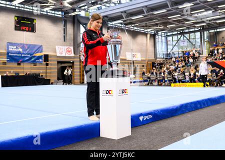 7 dicembre 2024, Saarland, Saarbrücken: Ginnastica: DTL Final 2024, Women, Joachim-Deckarm-Halle, Saarbrücken. Elisabeth Seitz di Stoccarda porta il trofeo DTL nella sala. Foto: Tom Weller/dpa Foto Stock