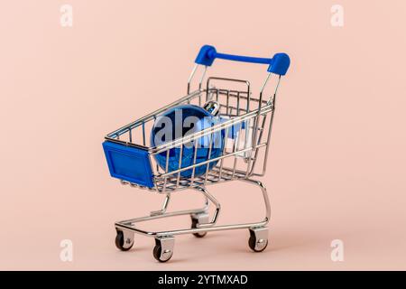 Primo piano del carrello della spesa con il giocattolo blu della palla dell'albero di Natale. Copia spazio. Foto Stock