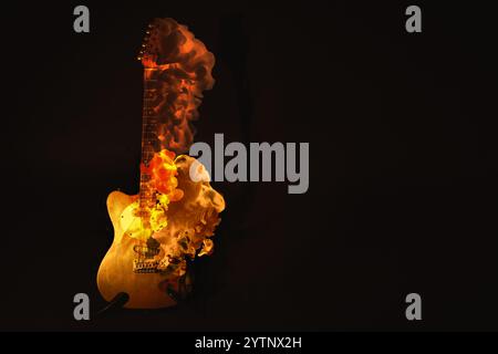 Chitarra elettrica in fiamme su sfondo scuro, spazio per il testo. Poster creativo Foto Stock