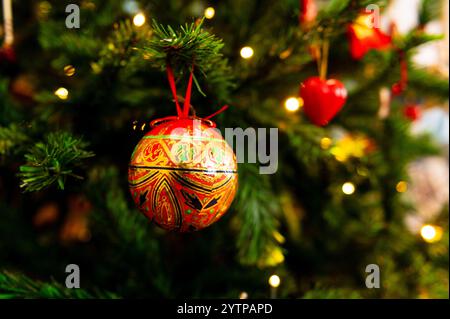 Vista di un albero di Natale vintage con una sfera rossa e dorata appesa a un ramo Foto Stock
